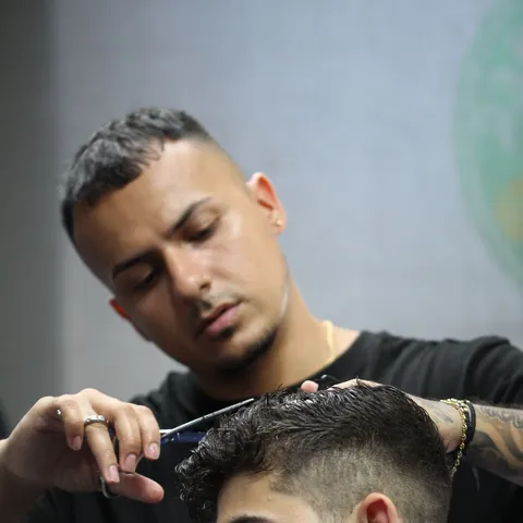 Barbero realizando un corte en Exclusive Barber